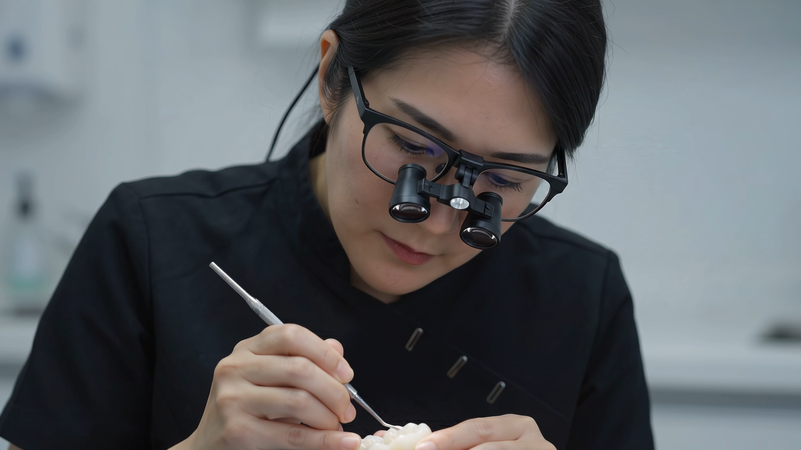Dr. Julie Su wearing dental loupes while providing precise dental treatment in Dubai